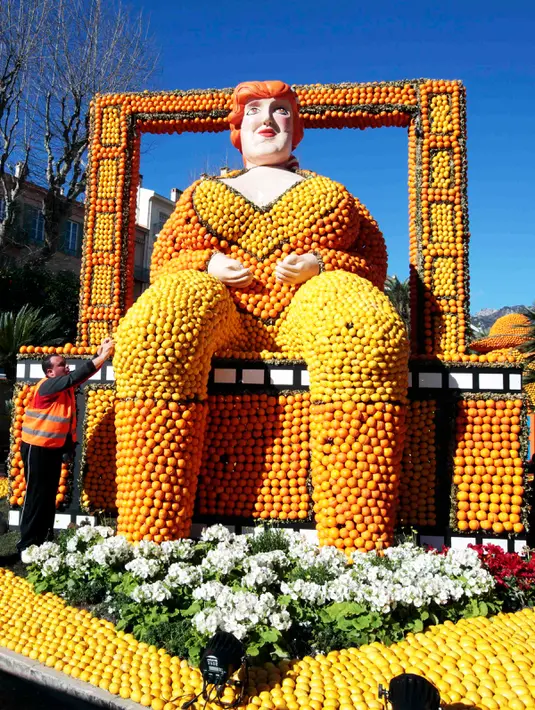 Pekerja merapikan susunan lemon dan jeruk yang menyerupai tubuh wanita di festival lemon, Menton , Prancis (10/2). 140 ton jeruk dan lemon dihabiskan untuk memeriahkan festival ini. (REUTERS/Eric Gaillard)