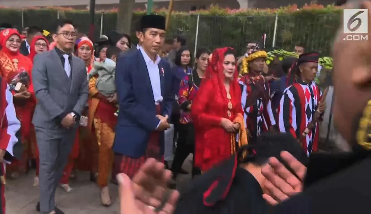 Presiden Joko Widodo dan Ibu Negara Iriana berjalan saat mengikuti  prosesi penyambutan keluarga mempelai wanita secara adat di Bukit Hijau Regency Taman Setia Budi (BHR Tasbi), Medan, Sabtu (25/11). (Liputan6.com/Vidio)