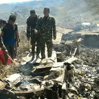 Tentara memeriksa puing dari pesawat Hercules TNI AU yang jatuh di kawasan Wamena, Papua, Minggu (18/12). Pesawat jenis C-130 HS A-1334 itu diduga jatuh menabrak Gunung Tugima sesaat akan mendarat di Bandara Wamena. (HANDOUT/SEARCH AND RESCUE TEAM/AFP)
