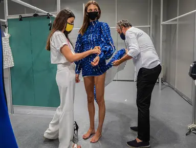 Desainer Spanyol Fernando Claro (kanan) bekerja di belakang panggung sehari sebelum dimulainya Mercedes-Benz Fashion Week di Madrid, Rabu (9/9/2020). Mode Spanyol berlangsung dari 10 - 13 September di bawah protokol kesehatan dan pedoman jarak sosial karena pandemi corona. (AP Photo/Bernat Armangue)