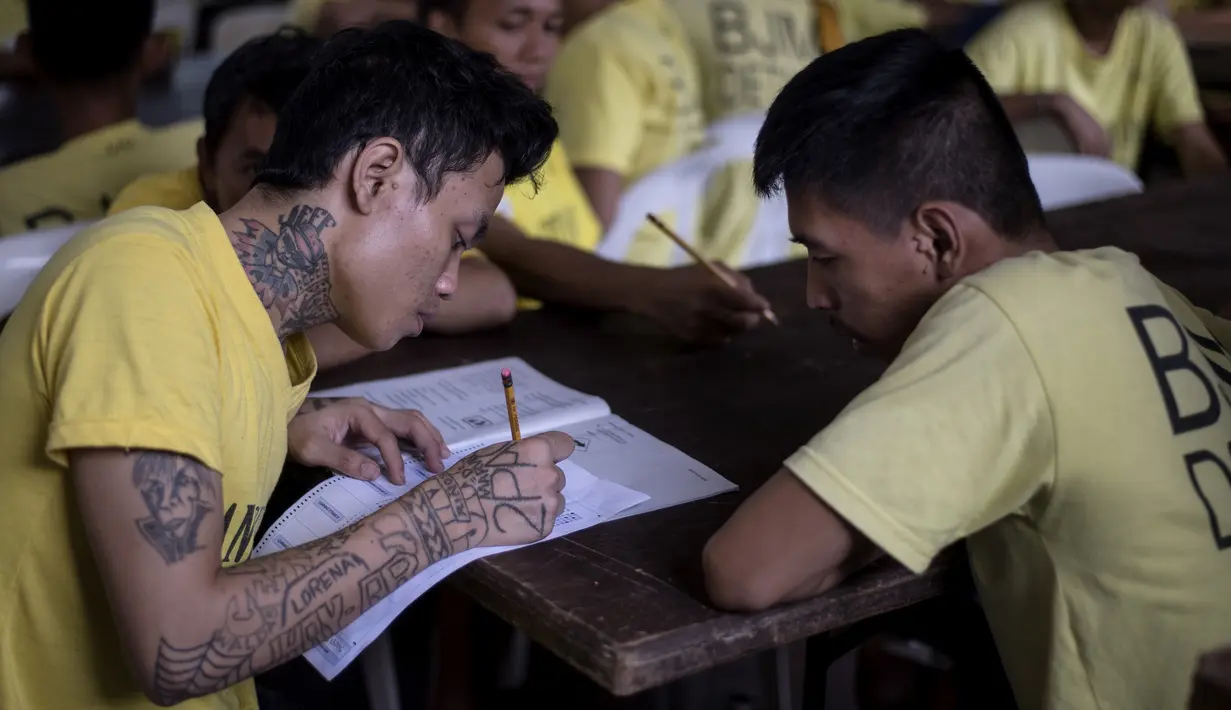 Narapidana mengikuti Ujian Akreditasi Nasional dan Pemeriksaan Kesetaraan di Penjara Manila City, Filipina, Minggu (19/11). Sekitar 900 napi, kebanyakan kasus narkoba, berpartisipasi dalam ujian sekolah dasar dan menengah atas. (NOEL CELIS/AFP)