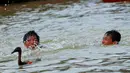 Terlihat dua bocah mengikuti lomba menangkap bebek di sungai Cisadane dalam rangka festival Peh Cun, Senin (2/6/14). (Liputan6.com/Faisal R Syam)