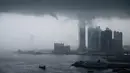 Pemandangan menunjukkan badai awan menutupi bangunan tertinggi Hong Kong, ICC (International Commerce Centre) sebelum hujan lebat, (6/3). (AFP Photo/Anthony Wallace)