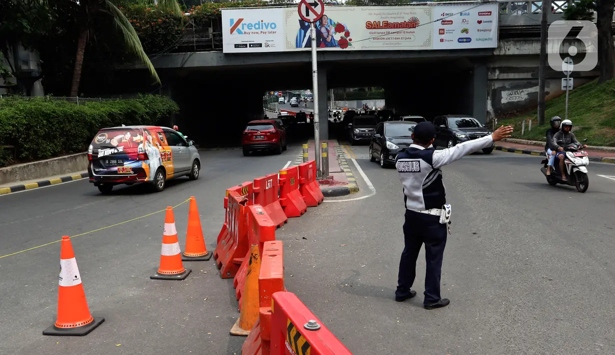 Petugas Dishub mengatur arus lalu lintas saat diberlakukan uji cobaSistem Satu Arah (SSA) di Jalan Margono Djoyohadikoesoemo, Jakarta, Sabtu (15/12/2019). Uji coba terkait adanya pembangunan stasiun LRT Jabodebek dan program Naturalisasi Kanal Banjir Barat. (Liputan6.com/Johan Tallo)