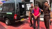 Tersangka korupsi di Bawaslu Indragiri Hulu digiring jaksa dari Kejari Indragiri Hulu ke mobil tahanan. (Liputan6.com/M Syukur)