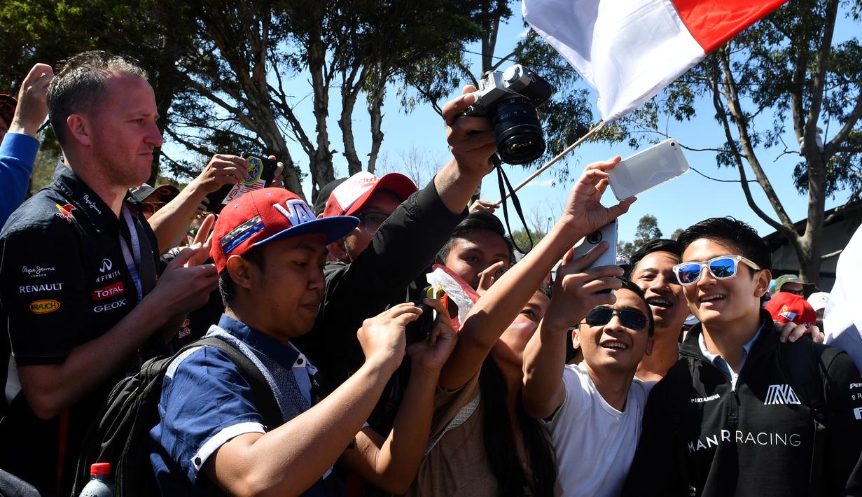 Pebalap Manor Racing asal Indonesia, Rio Haryanto, menyapa penggemar sebelum memulai balapan F1 GP Australia di Sirkuit Albert Park, Minggu (20/3/2016). (AFP/Paul Crock)