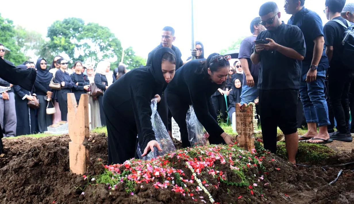 Selain Reza Arap, sejumlah kerabat dan sahabat Lula Lahfah juga tampak hadir mengiringi jenazah Lula Lahfah ke tempat peristirahatan terakhir. Tampak dalam foto, sejumlah kerabat dan sahabat menabur bunga di atas makam Lula Lahfah di Tempat Pemakaman Umum (TPU) Rawa Terate, Cakung, Jakarta Timur, pada Sabtu (24/1/2026). (Kapanlagi.com/Budy Santoso)