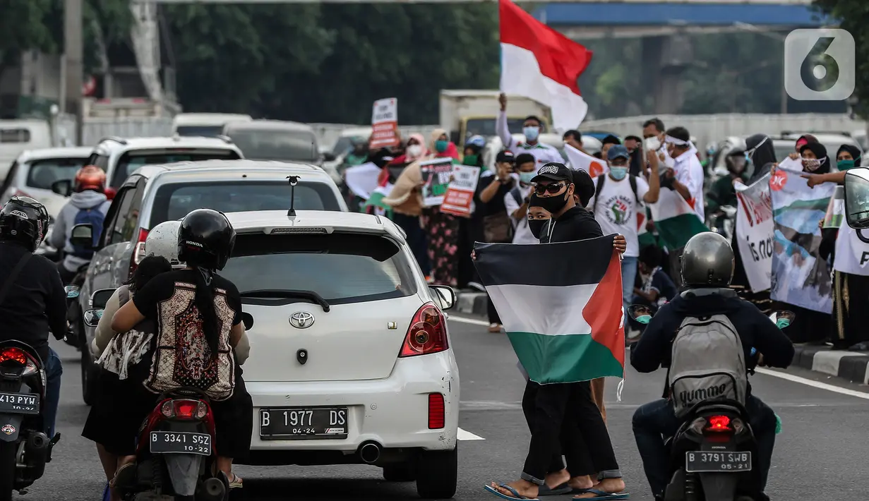 Masyarakat membawa bendera Palestina di jalan Basuki Rahmat, Jakarta, Kamis (20/5/2020). Aksi masyarakat tersebut untuk mengutuk penyerangan Israel ke Palestina yang telah menyebabkan ratusan korban jiwa. (Liputan6.com/Johan Tallo)