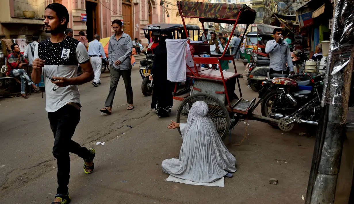 Seorang wanita mengemis di pinggir jalan di tempat-tempat tua di New Delhi, India, Rabu (10/10). Banyak warga miskin India bermigrasi ke kota-kota besar untuk mencari pekerjaan. (AP Photo / R S Iyer)