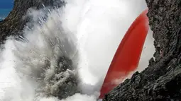 Reaksi ledakan saat lava meluncur ke air laut di Samudra Pasifik, Hawaii, Rabu (1/2). Fenomena mengalirnya lava bak air terjun ini menjadi daya tarik wisatawan. (Shane Turpin / Lava Ocean Tours via AP)