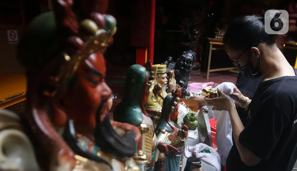 Warga keturunan Tionghoa melaksanakan tradisi membersihkan patung dewa-dewi atau rupang di Vihara Dhanagun, Kota Bogor, Rabu (27/1/2022). Proses pembersihan rupang ini biasa dilakukan sebagai tanda penyucian kembali sebelum merayakan dan memasuki Tahun Baru Imlek. (Liputan6.com/Helmi Fithriansyah)