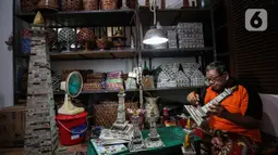 Sugito (68) menyelesaikan pembuatan miniatur Monas dari kertas koran bekas di Bank Sampah Tri Alam Lestari, Jakarta Selatan, Rabu (9/6/2021). Selain miniatur Monas, Sugito juga memanfaatkan kertas bekas untuk membuat berbagai macam barang kerajinan yang bernilai ekonomis. (Liputan6.com/Johan Tallo)
