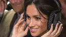 Meghan Markle (depan) dan Pangeran Harry (belakang) menjajal headset saat kunjungan ke stasiun radio Reprezent 107,3 FM di Brixton, London, Selasa, (9/1). Pasangan ini ingin melangsungkan pernikahan di Frogmore House. (AP Photo/Dominic Lipinski, Pool)