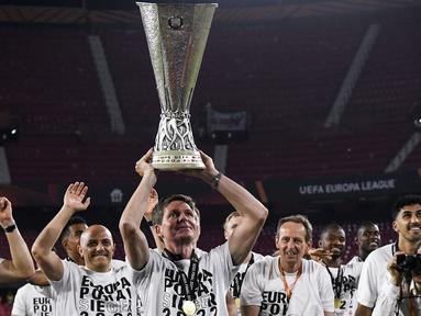Oliver Glasner sukses membawa Eintracht Frankfurt menjuarai Liga Europa 2021/2022. Gelar tersebut merupakan trofi pertama yang berhasil ia bersembahkan bersama Die Alder. Hebatnya lagi, pelatih asal Australia tersebut berhasil juara dengan status tak terkalahkan. (AFP/Cristina Quicler)