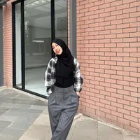 Padu padan plaid shirt dengan top hitam dan loose pants abu-abu sempurna untuk outfit kuliah.  [Instagram/adiba.knza]
