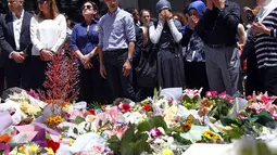 Sejumlah kaum muslim berdoa di dekat tumpukan karangan bunga untuk menghormati korban tewas dalam penyanderaan yang terjadi di Kafe Lindt, Sidney, Australia (16/12/2014). (REUTERS/David Gray)