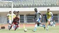 Ezechiel N'Douassel bersiap menendang bola ke gawang I Made Wirawan dalam sesi latihan di Stadion Gelora Bandung Lautan Api, Kamis (1/8/2019). (Liputan6.com/Huyogo Simbolon)