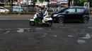 Pengendara mobil dan sepeda motor menghindari jalan yang ruas saat melintasi ruas Jalan Lapangan Ros, Tebet, Jakarta, Sabtu (11/5/2019). Jalan-jalan berlubang yang terisi air tersebut dapat mengakibatkan kecelakaan bagi pengendara kendaraan bermotor. (merdeka.com/Imam Buhori)