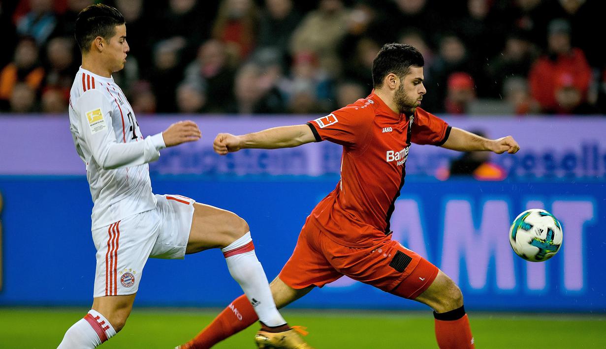 Aksi pemain Leverkusen, Kevin Volland melepaskan umpan saat dibayangi pemain Bayern Munchen, James Rodriguez (kiri) pada lanjutan Budesliga di Bay Arena, Laverkusen, (12/1/2018). Bayern Munchen menang 3-1. (AFP/Sascha Schuermann)