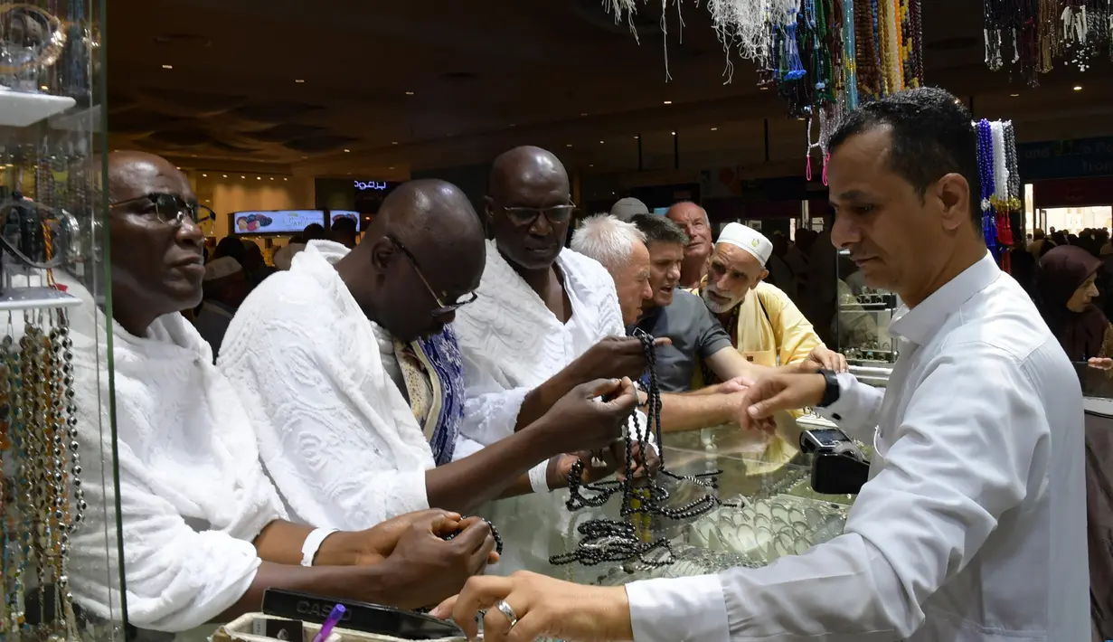 Jemaah haji memilih tasbih di sebuah toko di kota suci Makkah, Arab Saudi pada Selasa (6/8/2019). Puncak Ibadah haji masih beberapa hari lagi, namun jemaah sudah memborong aneka barang antara lain tasbih, baju, teko emas, kurma, sajadah, minyak wangi, pacar kuku, dan lainnya. (FETHI BELAID/AFP)
