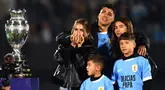 Pemain Uruguay, Luis Suarez (tengah) bersama istri (kiri) dan ketiga anaknya tak mampu membendung air mata saat acara perpisahannya dengan Timnas Uruguay sebelum laga kualifikasi Piala Dunia 2026 melawan Paraguay yang berlangsung di Stadion Centenario, Montevideo, Uruguay, Sabtu (07/09/2024) WIB. (AFP/Dante Fernandez)