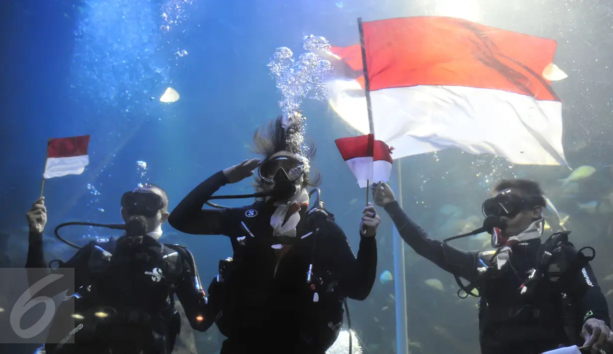 Chua ‘Kotak’ (tengah) saat memberikan penghormatan usai pengibaran bendera di dalam akuarium Seaworld, Ancol, Jakarta, Senin (17/8/2015). Acara tersebut untuk memeriahkan hari kemerdekaan RI ke-70.(Liputan6.com/Herman Zakharia)