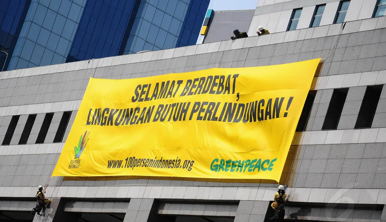 Aksi aktivis Greenpeace saat memasang spanduk di Gedung Bidakara, Jakarta, Jumat (4/7/14). (Liputan6.com/Faizal Fanani)