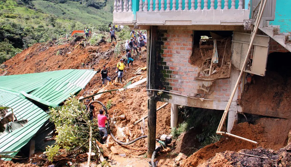Warga mencari korban selamat setelah tanah longsor mengubur dua rumah di Mallama, Provinsi Narino, Kolombia, 2 November 2021. Sebanyak empat orang tewas dan beberapa dikhawatirkan terjebak menyusul longsor akibat hujan deras di daerah tersebut. (LEONARDO CASTRO/AFP)