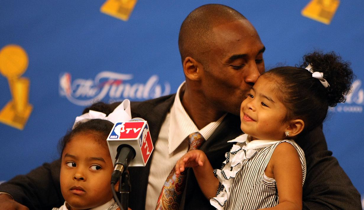 Pebasket LA Lakers, Kobe Bryant, mencium putrinya Gianna usai mengalahkan Boston Celtics pada laga NBA di Staples Center, Los Angeles, Sabtu (15/6/2008). (AFP/Jed Jacobsohn)