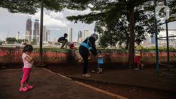 Sejumlah anak bermain di taman bermain yang terdapat di Bantaran Banjir Kanal Barat Kawasan Petamburan, Jakarta, Minggu (12/12/2021). Minimnya taman bermain di pemukiman padat penduduk membuat anak-anak seringkali bermain di tempat yang tidak semestinya. (Liputan6.com/Faizal Fanani)