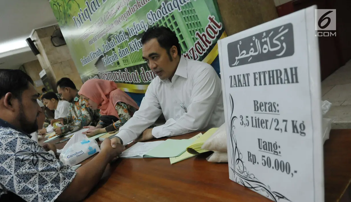 Petugas zakat melakukan ijab penerimaan zakat di Masjid Istiqlal, Jakarta, Jumat (1/7). Waktu pembayaran dibuka hingga malam takbiran dengan pembayaran zakat senilai Rp50ribu dan beras 3,5 liter. (Liputan6.com/Helmi Afandi)