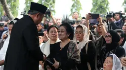 Presiden ke-6 RI Susilo Bambang Yudhoyono bersalaman dengan Presiden ke-5 RI Megawati Soekarnoputri usai prosesi pemakaman Ani Yudhoyono di TMP Kalibata, Jakarta, Minggu (2/6/2019). Megawati tampak melempar senyum kepada SBY disamping Sinta Nuriyah Wahid. (Liputan6.com/HO/Rangga)