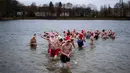 Para anggota klub renang "Berliner Seehunde" (Berlin Seals) berenang di Danau Orankesee yang dingin di Berlin, Jerman, Senin (25/12). Berenang di danau itu salah satu tradisi masyarakat Berlin menyambut Natal setiap tahun. (AP/Markus Schreiber)