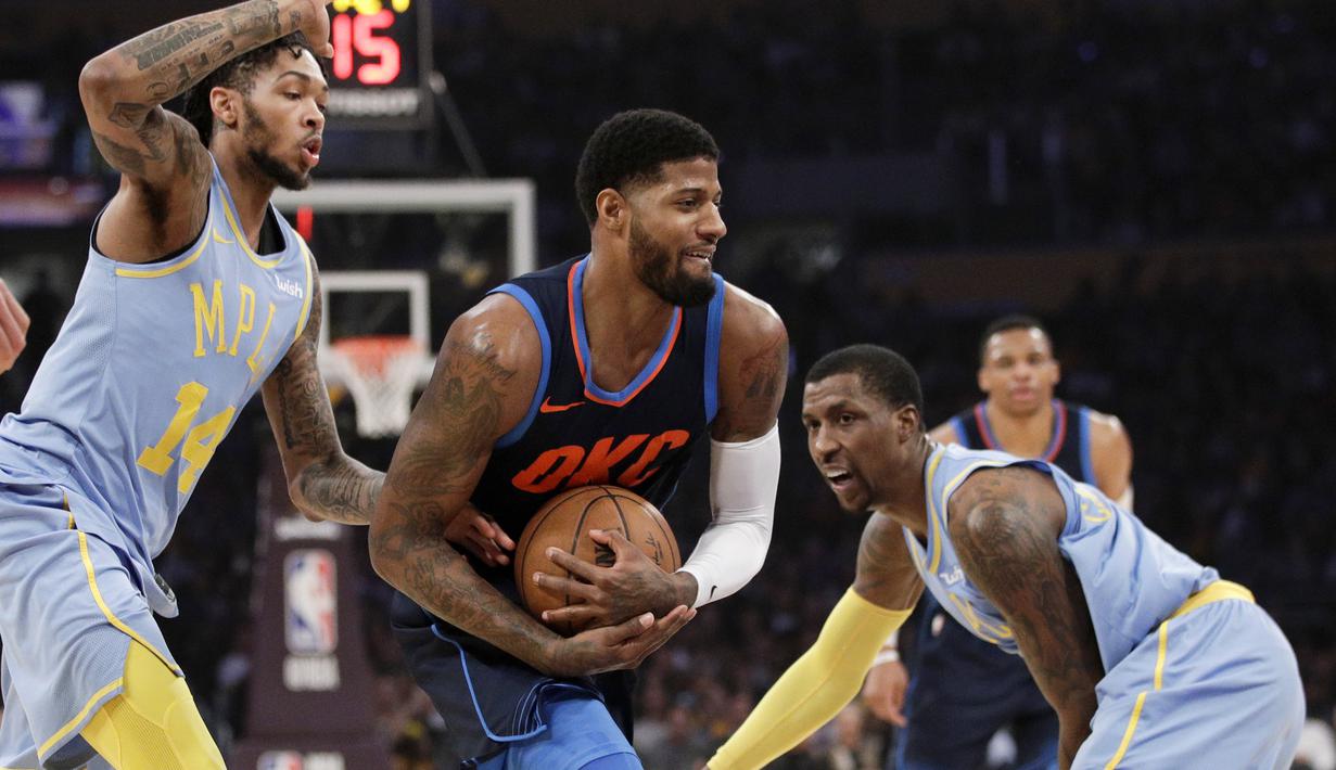 Pemain Oklahoma City Thunder, Paul George (tengah) mencoba melewati adangan dua pemain Los Angeles Lakers pada laga NBA basketball game di Staples Center, Los Angeles, (3/1/2018). Lakers kalah 96-133. (AP/Jae C. Hong)