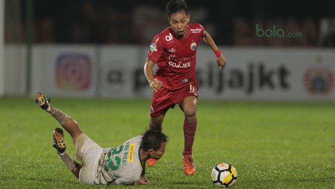 Pemain Persija Jakarta, Novri Setiawan berusaha melewati adangan pemain Persebaya Surabaya, Abu Rizal (bawah)  pada laga Gojek Liag 1 bersama Bukalapak di Stadion PTIK, Jakarta (26/6/2018). Persebaya unggul sementara 1-0. (Bola.com/Nick Hanoatubun)