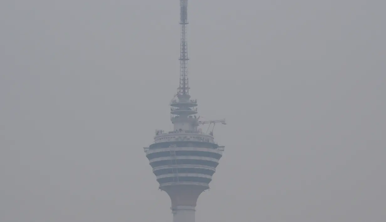Menara Kuala Lumpur terlihat diselimuti kabut asap di Kuala Lumpur (10/9/2019). Ratusan sekolah di seluruh Asia Tenggara diliburkan menyusul memburuknya udara akibat kabut asap kebakaran hutan di wilayah itu. (AFP Photo/Mohd Rasfan)