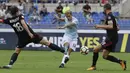 Aksi pemain Lazio, Luis Alberto (tengah) melakukan tembakan melewati dua pemain AC Milan pada lanjutan Serie A di Rome Olympic stadium, (10/9/2017). Lazio menang 4-1. (AP/Alessandra Tarantino)