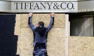 Pekerja menutup etalase toko merek perhiasan mewah Tiffany & Co. di kawasan Kurfürstendamm, Berlin, pada 30 Oktober 2026, sehari sebelum demo pemuda berskala nasional yang diumumkan oleh inisiatif "GenZ regelt" (Gen Z akan mengambil kendali). (John MacDougall/AFP)