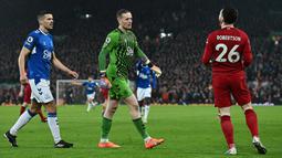 Kiper Everton, Jordan Pickford, menghampiri pemain Liverpool, Andrew Robertson, pada laga Liga Inggris di Stadion Anfield, Selasa (14/2/2023). Pickford menghampiri Robertson lantaran geram karena sang bek kedapatan menggiring bola ketika pluit sudah berbunyi tanda adanya pelanggaran. (AFP/Paul Ellis)