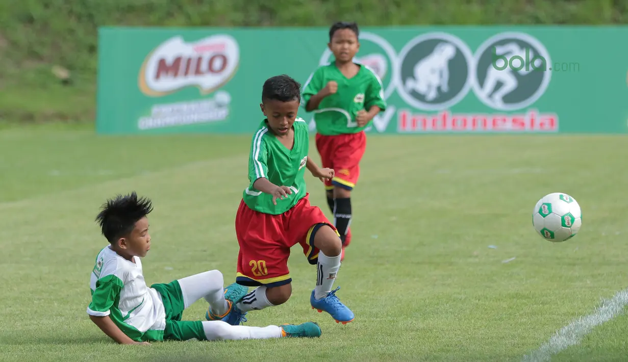 Pemain Al Hidayah (kiri) menghalau bola dari pemain SD Angkasa 9 pada ajang MILO Football Championship 2018 di Lapangan Panahan GBK, Jakarta, (24/3/2018). Sekitar 128 sekolah dasar di Jakarta meramaikan ajang tersebut. (Bola.com/Nick Hanoatubun)