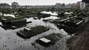 Kondisi ratusan makam yang terendam banjir di TPU Semper, Jakarta, Selasa (4/12). TPU Semper menjadi langganan banjir saat musim penghujan akibat rendahnya permukaan tanah dengan ketinggian air sepinggang orang dewasa. (Merdeka.com/Iqbal S. Nugroho)