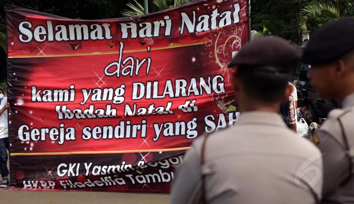 Sebuah spanduk ucapan Natal dibentangkan para jemaat HKBP Filadelfia dan GKI Yasmin saat merayakan ibadah di depan Istana Merdeka Jakarta, Kamis (25/12/2014). (Liputan6.com/Faizal Fanani)