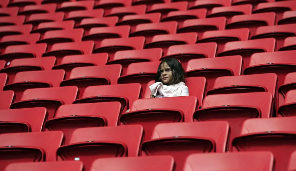 Meski harus datang lebih awal, salah satu bocah tetap setia duduk menanti bergulirnya laga penyisihan Piala Dunia Grup E antara Swiss kontra Ekuador di Estadio Nacional de Brasilia, (15/6/2014). (AFP PHOTO/Adrian Dennis)