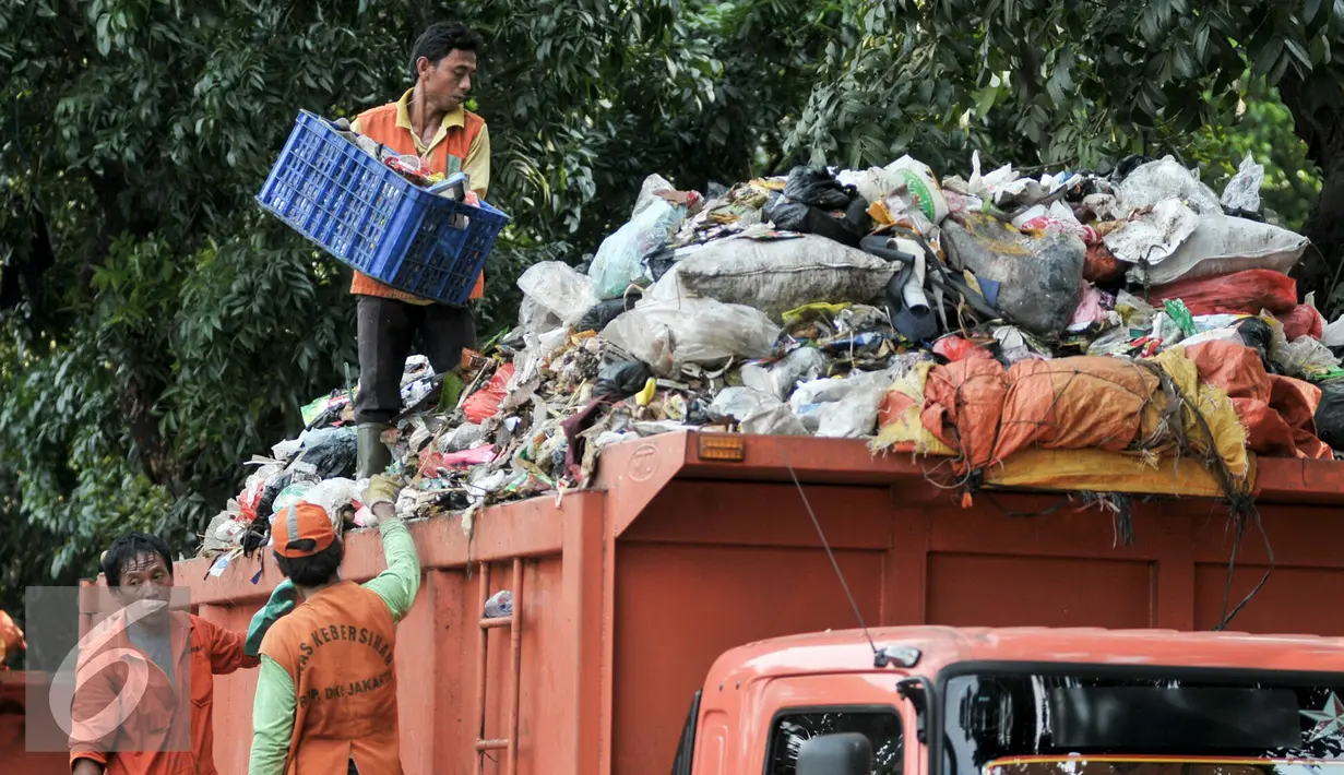 Pekerja Sudin Kebersihan Jagakarsa mengangut sampah dari mobil bak di TPS sementara, Jakarta, Senin (11/7). Pasca libur Lebaran, volume sampah di Kecamatan Jagakarsa diperkirakan mencapai 200 ton. (Liputan6.com/Yoppy Renato)