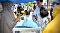 Presiden Jokowi memberikan bantuan modal usaha kepada pedagang kue di Sorong, Papua Barat yang sempat membentangkan spanduk untuknya. (Foto: Setpres)