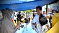 Presiden Jokowi memberikan bantuan modal usaha kepada pedagang kue di Sorong, Papua Barat yang sempat membentangkan spanduk untuknya. (Foto: Setpres)