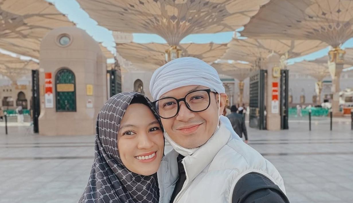 Genap 11 tahun menikah pada 22 Maret 2025 mendatang, rumah tangga Dude Harlino dan Alyssa Soebandono jauh dari gosip miring. Keharmonisan rumah tangga pasangan yang terpaut usia 11 tahun ini tentunya menjadi inspirasi untuk tak sedikit orang. Pamer senyuman dengan latar belakang payung di Masjid Nabawi yang sedang terbuka, pasangan artis mirip. (Liputan6.com/IG/@ichasoebandono)