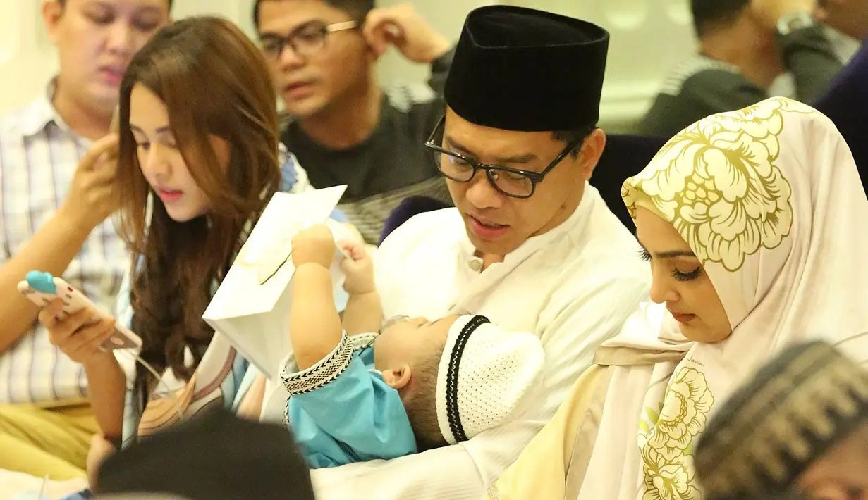 Berada di pangkuan sang ayah, Arsya dengan baju koko dan peci hajinya juga memegang buku yasin. Tak sedikit pun ia merasa lelah atau ngantuk berada di tengah pengajian tersebut. (Bambang E.Ros/Bintang.com)