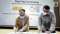 Resident Representative UNDP Indonesia, Norimasa Shimomura (kiri) dan Presdir & CEO Indosat Ooredoo, Ahmad Al-Neama (kanan) menandatangani MoU penanggulangan pandemi COVID-19 dan percepatan pencapaian Tujuan Pembangunan Berkelanjutan (SDGs) di Jakarta, Rabu (31/3/2021). (Liputan6.com/Pool/Indosat)
