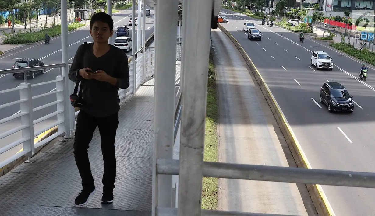 Pejalan kaki melintasi halte busway di Jalan Jenderal Sudirman, Jakarta, Selasa (5/2). Libur Tahun Baru Imlek 2019 menyebabkan ruas jalan protokol di Ibukota bebas dari kemacetan dibandingkan dengan hari biasa. (Liputan6.com/Immanuel Antonius)